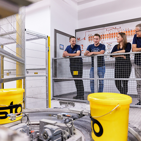 Mitarbeiter stehen in Fabrik für Baustoffe