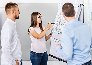 Frau zeichnet IT Ntzwerk auf Flipchart