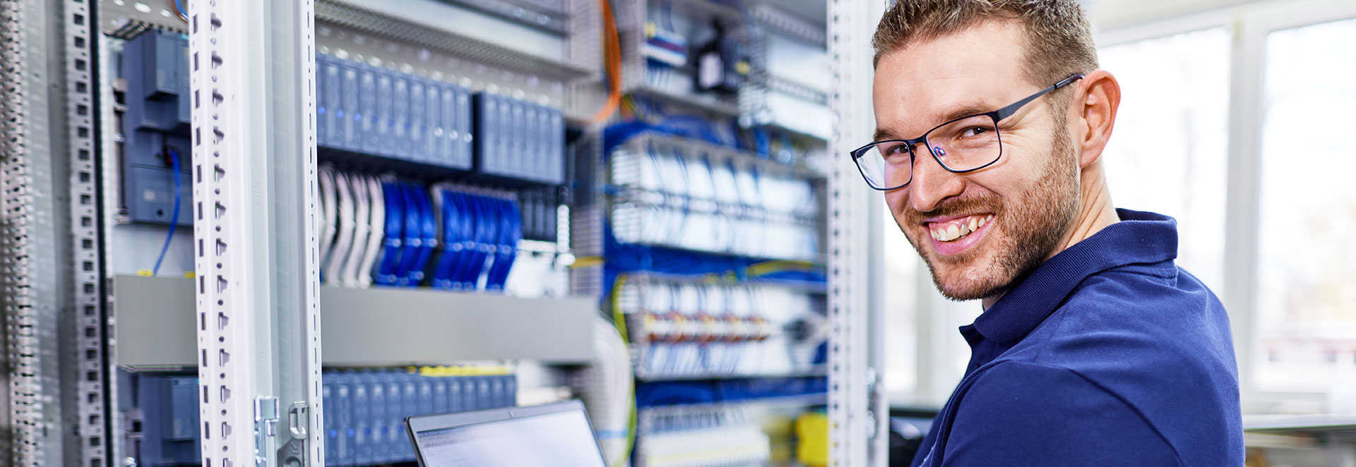 Mitarbeiter steht vor SPS