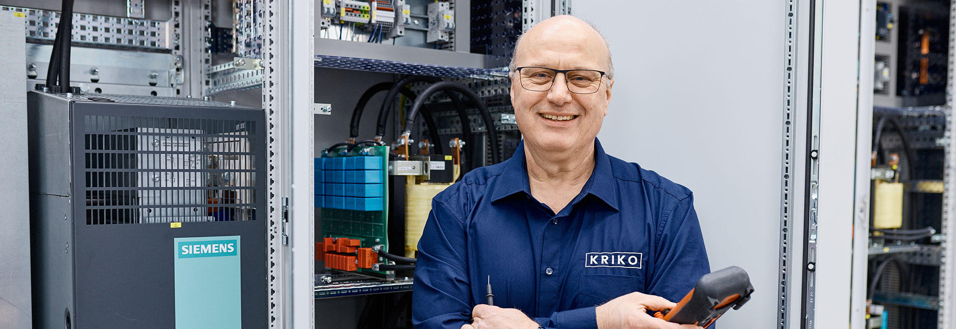 Mitarbeiter steht vor Netzwerkschrank