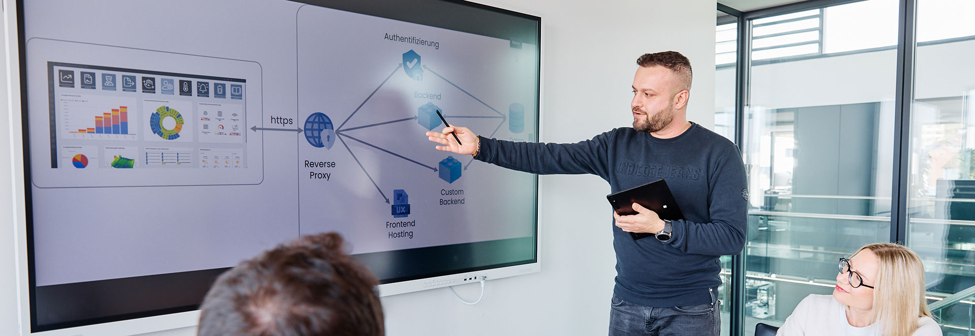 Softwareentwickler erklärt etwas vor Bildschirm