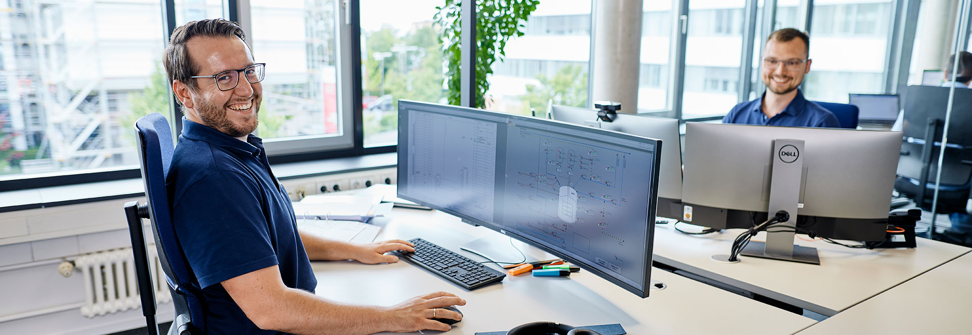 Zwei Mitarbeiter sitzen vor dem PC