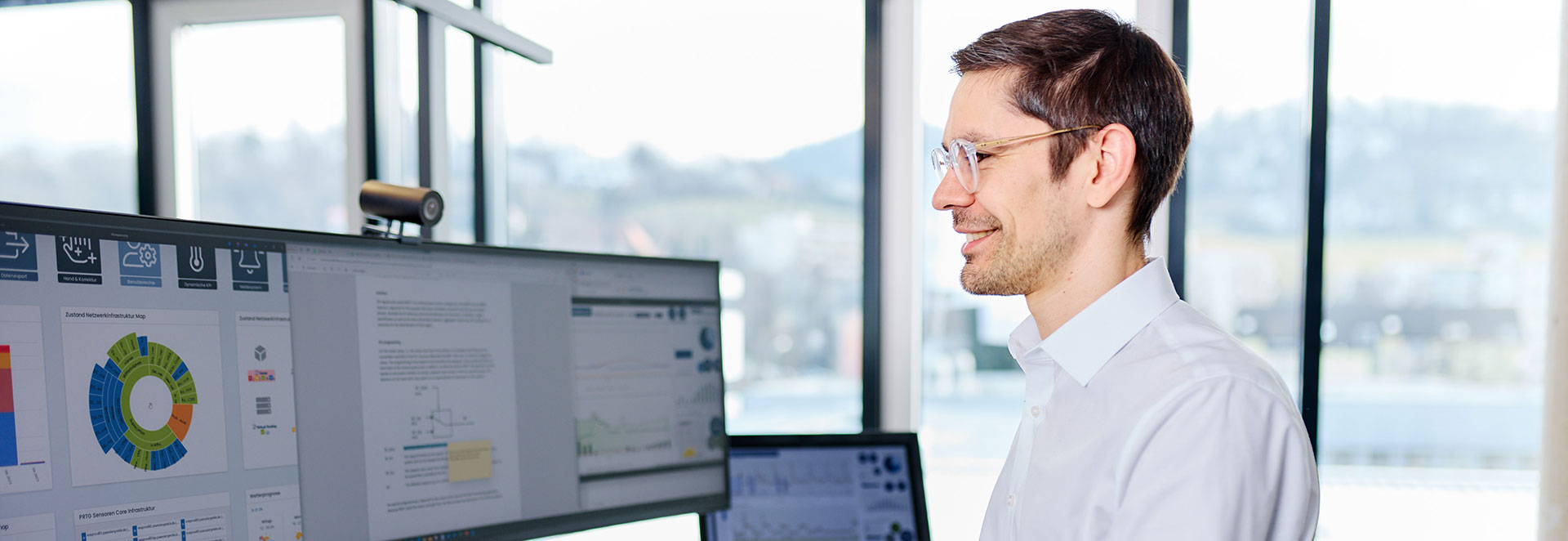 Mitarbeiter steht vor Bildschirm