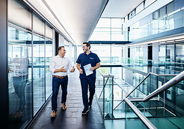 Zwei Kollegen unterhalten sich in Bürogebäude