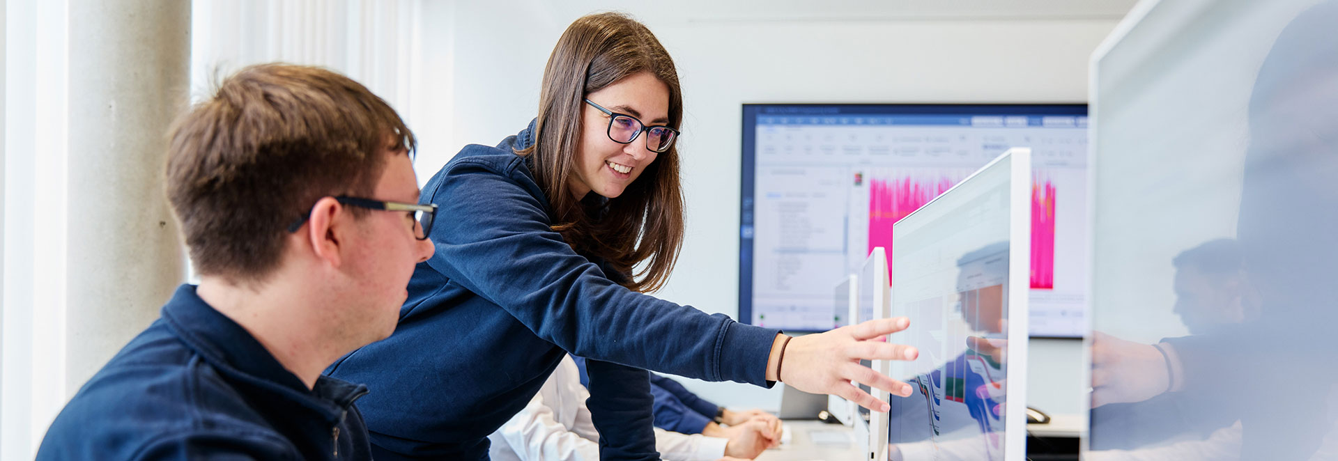 Mitarbeiter zeigt anderer Person etwas auf einem Bildschirm