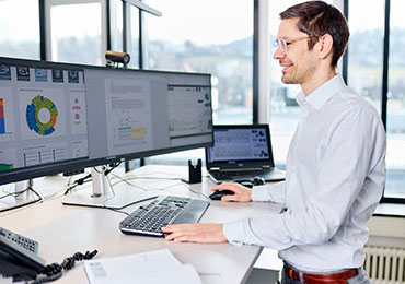 Mitarbeiter mit Tablet vor Papiermaschine