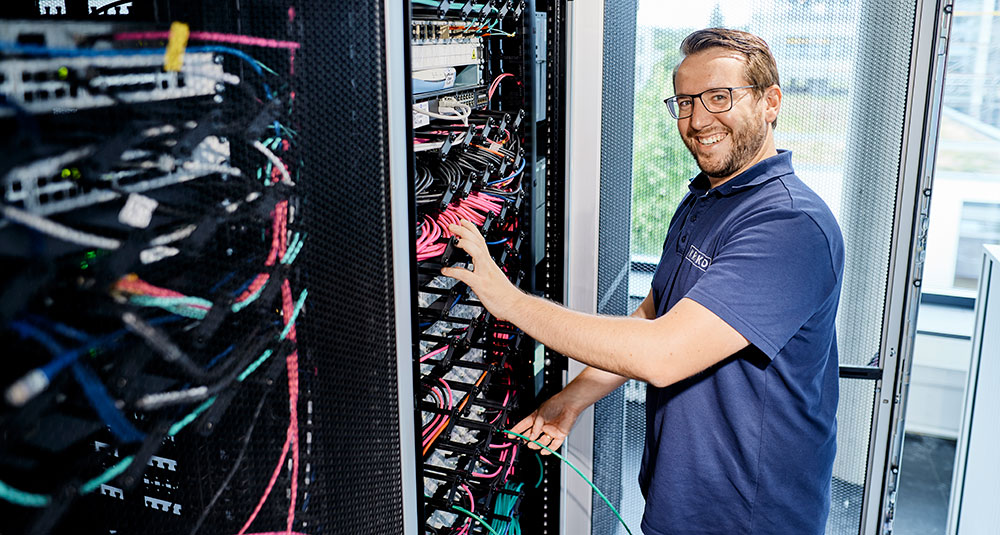 Mitarbeiter arbeitet an Netzwerkschrank