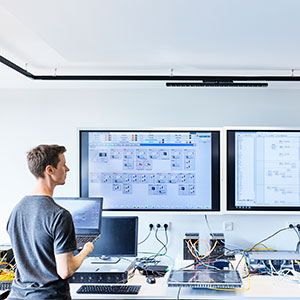 Techniker steht vor Monitor mit Prozessleitsystem