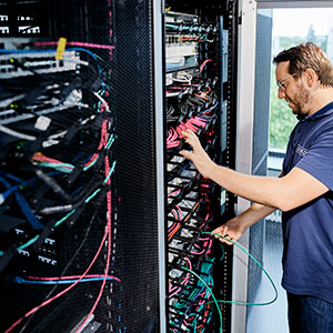 [Translate to English:] Techniker steht vor Netzwerkschrank