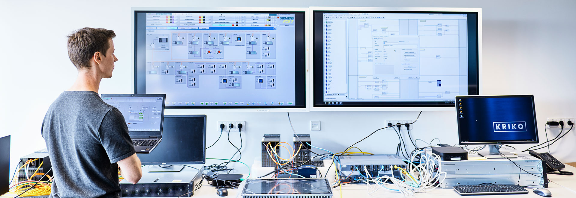 Techniker steht vor Monitoren mit Prozessleitsystem PCS 7
